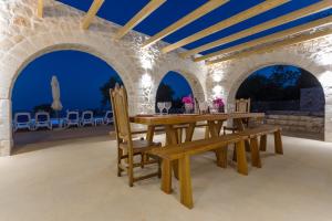 uma sala de jantar exterior com uma mesa de madeira e cadeiras em Indigo Villa em Ágios Nikolaos