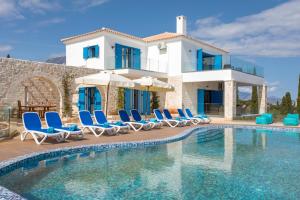 a villa with a swimming pool in front of a house at Indigo Villa in Agios Nikolaos