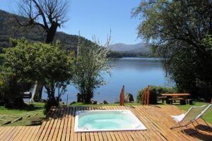 a swimming pool on a deck with a view of a lake at Allá Ité in San Carlos de Bariloche