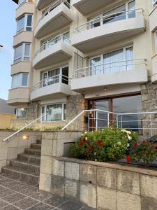 a building with stairs and flowers in front of it at Frente al lago in San Carlos de Bariloche