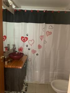 a bathroom with a shower curtain with hearts on it at Frente al lago in San Carlos de Bariloche
