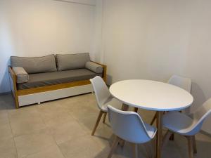 サン・カルロス・デ・バリローチェにあるFrente al lagoのテーブル、ソファ、テーブル、椅子が備わる客室です。