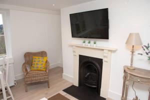 a living room with a fireplace and a television on a wall at Spectacular views, 1 Bed Central Bath Apartment in Bath