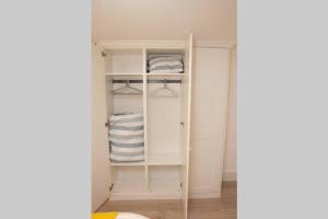 a walk in closet with white cabinets and towels at Spectacular views, 1 Bed Central Bath Apartment in Bath