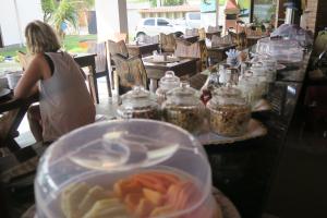 a woman sitting at a counter with jars of food at Pousada Kite Da Mary Cumbuco in Cumbuco