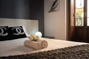 1 dormitorio con 1 cama con toalla enrollada en Apartamentos Day Madrid CORREDERA Centro Gran Via Sol Malasaña, en Madrid