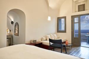 a hotel room with a bed and a couch at Old Castle Oia in Oia