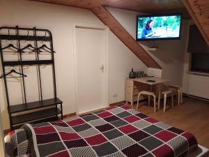 ein Schlafzimmer mit einem Bett und einem TV an der Wand in der Unterkunft Imagine in Aan de Wolfsberg