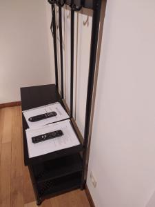 a black stand with two remotes on it next to a refrigerator at Imagine in Houthalen-Helchteren