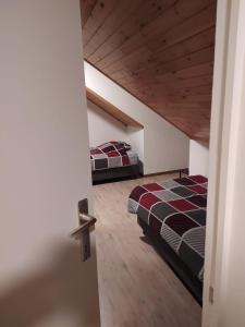 1 Schlafzimmer mit 2 Betten und Holzdecke in der Unterkunft Imagine in Aan de Wolfsberg