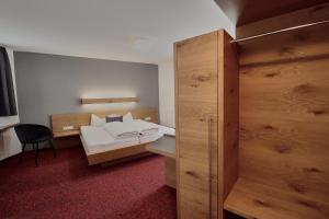 ein Schlafzimmer mit einem Bett und einem Holzschrank in der Unterkunft Hotel Garni & Aparthotel COLLINA in Ischgl + 16 Fotos