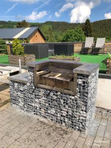 a stone fire pit in a yard with a patio at Le Loft in Stoumont