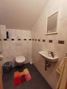 ein Badezimmer mit einem Waschbecken, einem WC und einem Spiegel in der Unterkunft Haus Wiesenheim in Heiligenblut