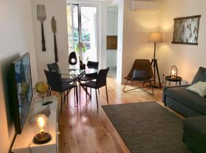 uma sala de estar com um sofá e uma mesa com cadeiras em WHome Modern 1-Bed with AC & private Terrace em Lisboa