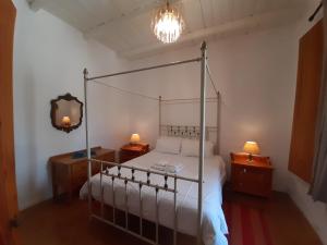 een slaapkamer met een hemelbed met 2 nachtkastjes en 2 lampen bij Quince&Cottage in Nieu-Bethesda