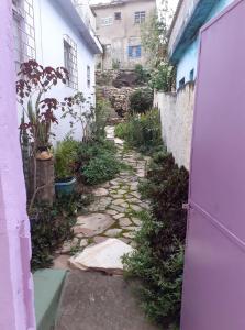 un callejón con una puerta púrpura al lado de un edificio en Portal Amor e Luz Hospedagem, en São Thomé das Letras