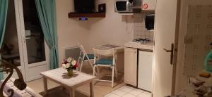 a small kitchen with a vase of flowers on a table at La petite sirène in Sahurs