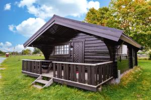 a small wooden cabin in a field of grass at Hamre Familiecamping in Kristiansand
