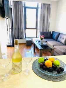 una botella de vino y un plato de fruta en una mesa en Sunny Apartment Dilijan, en Dilijan