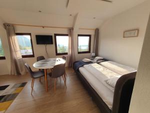 a bedroom with a bed and a table with chairs at Jelka apartmani in Jahorina