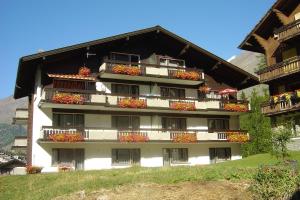 ein Apartmenthaus mit Blumenkästen auf den Balkonen in der Unterkunft Haus Amor in Saas-Fee