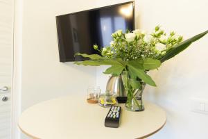 马尔萨拉Cozy apartment in Marsala 27 m² with garden balcony的花瓶,花瓶,桌子上放着电视机