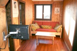 a living room with a red couch and a table at Chalet de 3 chambres a Chamonix Mont Blanc a 200 m des pistes avec terrasse amenagee et wifi in Chamonix-Mont-Blanc