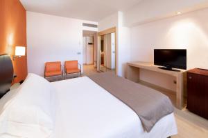 a hotel room with a bed and a flat screen tv at Hotel Cristina by Tigotan Las Palmas - Adults Only in Las Palmas de Gran Canaria