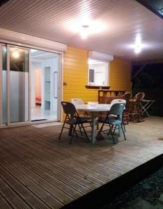 a dining area with a table and chairs on a deck at Maison cosy Le Lamentin, jardin in Le Lamentin