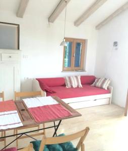 a living room with a red couch and a table at Charming apartment in Zambratija, 44 sqm, Parking included in Zambratija