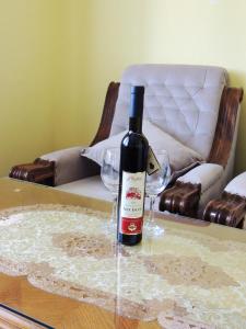 uma garrafa de vinho sentada numa mesa com copos em 2 bedrooms apartement with sea view enclosed garden and wifi at Ulcinj 1 km away from the beach em Ulcinj