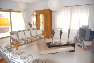 a living room with a couch and a tv at 3 bedrooms villa with sea view private pool and enclosed garden at Peyia 3 km away from the beach in Peyia