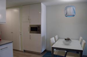 una cucina con tavolo, sedie e forno a microonde di One bedroom appartement with sea view and wifi at Encarnacao 3 km away from the beach a Encarnação