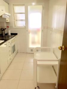 a white kitchen with a sink and a window at Comfortable seaside apartment in Salou - 85 m² - Sea view in Salou +41 photos