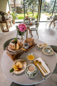 un tavolo con prodotti per la colazione e fiori di San Baio B&B a Cecina