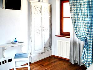 um quarto com uma cadeira, uma mesa e uma janela em 6 bedrooms villa with private pool furnished garden and wifi at Mombarcaro em Tetti