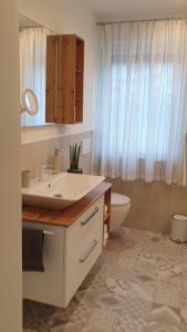 a bathroom with a sink and a toilet and a mirror at Ferienwohnung zum Wohlfühlen in Lengerich