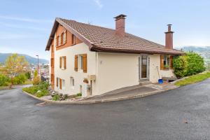 ein kleines weißes Haus an der Straßenseite in der Unterkunft Studio avec vue sur le lac jardin amenage et wifi a Gerardmer a 1 km des pistes in Gérardmer