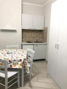 ナポリにあるOne bedroom apartement with wifi at Napoliのキッチン(テーブル、椅子付)、キッチン(白いキャビネット付)
