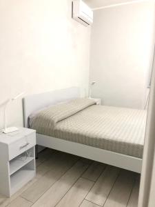 ナポリにあるOne bedroom apartement with wifi at Napoliの白いベッドルーム(ベッド1台、ナイトスタンド付)