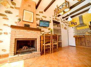 a living room with a stone fireplace in a house at Cozy Chalet in Laroya + Pool in Laroya