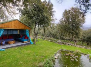 un cenador en un campo junto a un estanque en Studio avec jardin amenage et wifi a Moltifao, en Moltifao