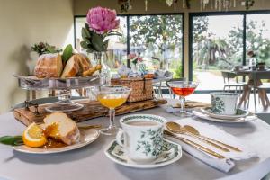 - une table de petit-déjeuner avec un plateau de pain et des boissons dans l'établissement San Baio B&B, à Cecina