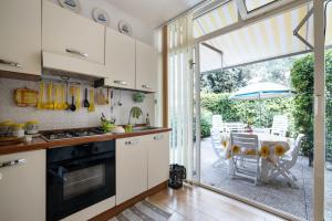 a kitchen with white cabinets and a table with an umbrella at 3 bedrooms house at Sabaudia 800 m away from the beach with lake view and enclosed garden in Sabaudia