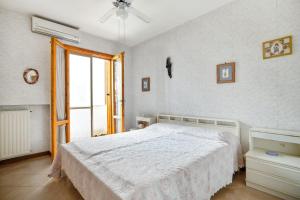 a bedroom with a white bed and a window at 3 bedrooms house at Sabaudia 800 m away from the beach with lake view and enclosed garden in Sabaudia
