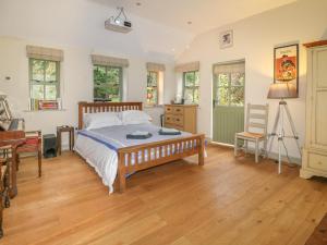 ein Schlafzimmer mit einem Bett und einem Holzboden in der Unterkunft Sunny Cottage in Grantham
