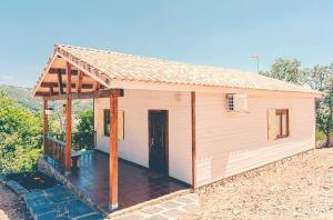a small house with a porch and a roof at Welcoming House in Cañamero + Pool in Cañamero