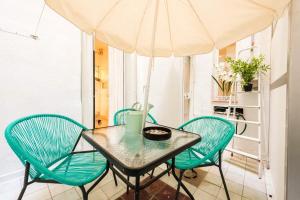una mesa con 4 sillas y una sombrilla en One bedroom appartement with wifi at Madrid, en Madrid