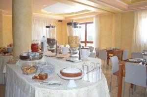 a table with a cake and other food on it at Hotel Parco Serrone in Corato