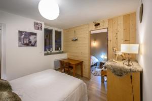 a bedroom with a bed and a desk in a room at Appartement spacieux à Orcières – Vue sur la montagne. in Orcières
